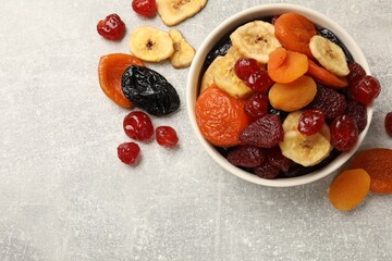Mix of delicious dried fruits on grey table, flat lay. Space for text