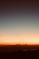 sunset and moon over mountains