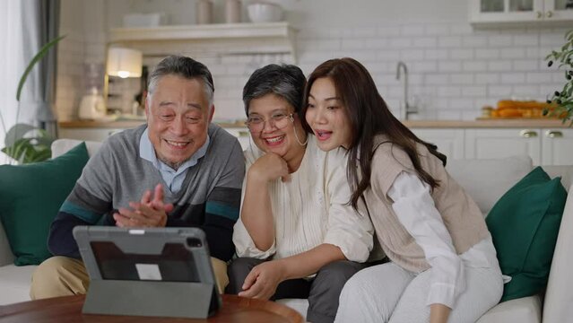 Happy asian senior elderly and daughter have fun with smartphone to talk to online wave hand to webcam glad to say hello.Smiling mature male calling,app for video conversations,enjoy family retirement