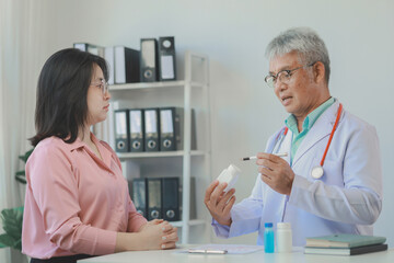 Obraz premium The doctor is explaining the details of the medicine that the patient must take, A patient comes to see the doctor about the problem of side effects from taking medicine.