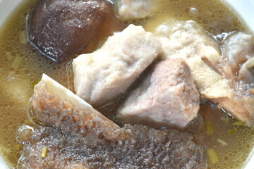 boiled fried grouper fish head and slice taro with black mushroom in soup on bowl dipping spicy chili soy sauce