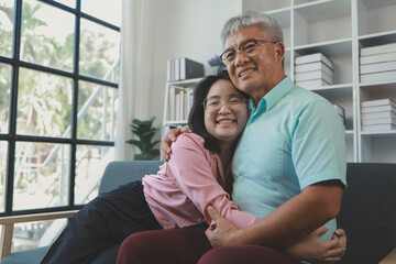 A father and daughter sat in the living room happily spending time together after not seeing each other for a while, A warm family is in the house, Elderly father and teenage daughter