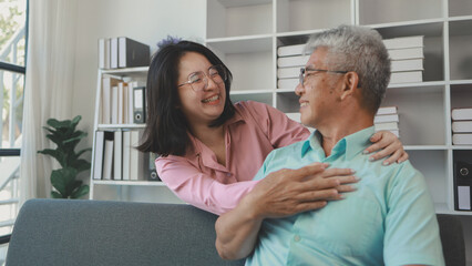 Fototapeta premium A father and daughter sat in the living room happily spending time together after not seeing each other for a while, A warm family is in the house, Elderly father and teenage daughter