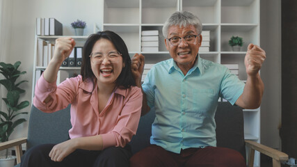 Obraz premium Asian father and daughter spend a happy weekend together in their home, A family of father and daughter happily do various activities together in the living room and spend quality time together.