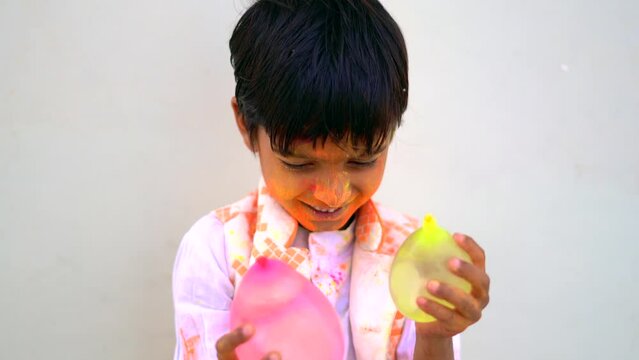 Happy india kids playing holi with water balloon. Holi celebrations in India.