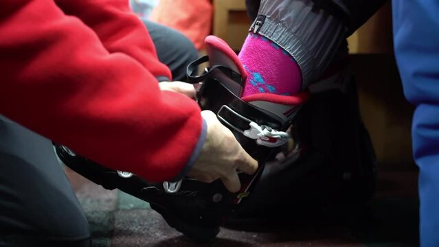 Male employee fitting ski boots at a company that rents ski equipment