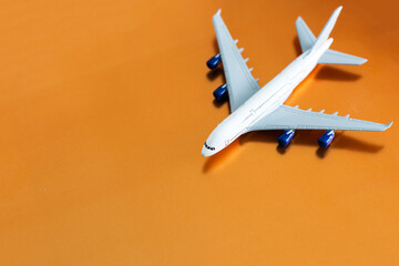 Airplane on orange background, flat lay, travel concept