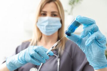 COVID-19 vaccine in researcher hands, female doctor's holds syringe and bottle with vaccine for coronavirus cure. Concept of corona virus treatment, injection, shot and clinical trial during pandemic.