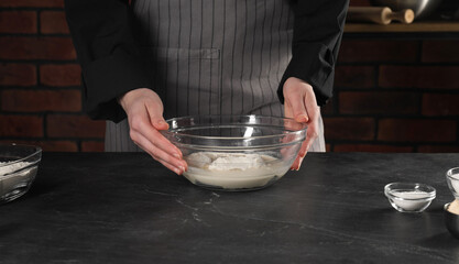 Making bread. Woman with ingredients at grey textured table in kitchen, closeup