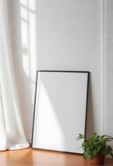 An empty picture frame, with a small green plant in the bottom right corner