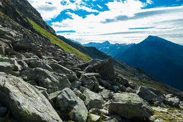 Lush green alpine meadow with panoramic view of majestic mountain peaks of High Tauern National...