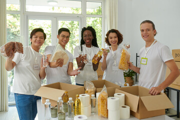 Group of happy volunteers packing food donated for people in need