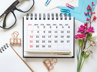 Calendar lies on the table in the office. Daylight. Close-up, indoors. Studio shot. Finance and business concept. Planning working hours and working day