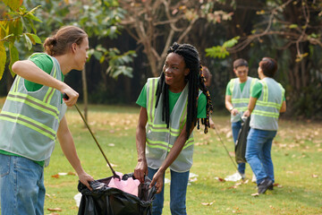 Group of positive volunteers collecting garbage in local park