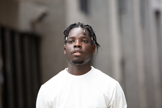 Portrait of young African American male showing short black hair braided hairstyle in the city outdoor