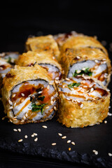 fried tempura Hokkaido rolls on a black stone
