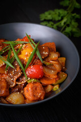 Korean food, Tofu with vegetables and meat in sauce on a black background