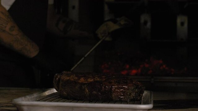 chef drops a cube of beef fat into a hot iron to flamb&eacute; a steak	
