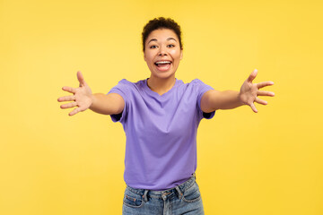 Young African American woman, exhibiting smile and gesturing welcoming embrace at camera