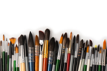 Mix of paint brushes in a row isolated on a white background.