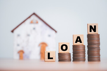 Loan wording on increasing coins stacking with house model background for financial from real estate mortgage growing after central bank increase interest rating concept. - obrazy, fototapety, plakaty