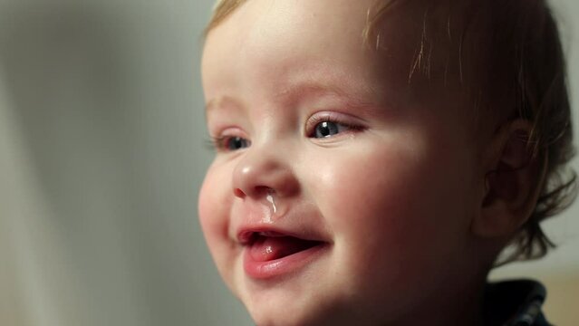 A little boy, he has a runny nose. Cold, virus or flu. The child's sleepy appearance fell ill, a boy with blond hair and blue eyes