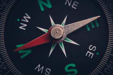 Dial compass in closeup, arrow indicates direction west.