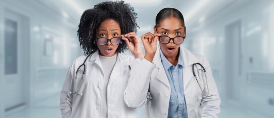 Two surprised female doctors in lab coats are adjusting their glasses in a hospital - Powered by Adobe