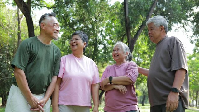 Group of elderly Asians exercising in outdoor park Join hands and join together in unity. Health care in retirement. Elderly society. sports concept