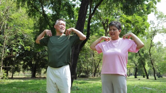 Elderly Asian couple standing and exercising in an outdoor park. Sports concept. Health care