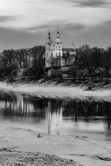Black and white photograph of Polotsk St. Sophia Cathedral with reflection in the Western Dvina River at sunset