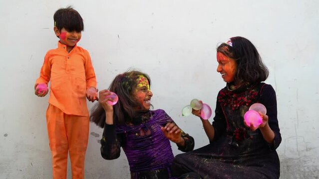 Happy india kids playing holi with water balloon. Holi celebrations in India.