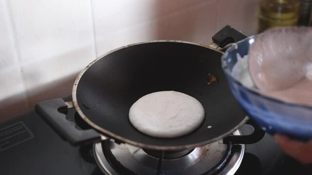 Women cooking making Appam Kerala breakfast food best served with Curry Masala and milk tea chai, Christian breakfast on dark black background. fermented rice pan cake. Top view of Indian veg food.