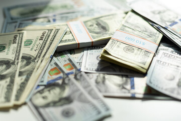 One hundred dollars pile as background. Many American dollars are slowly falling onto the table. Man throws green american money. American financial system.