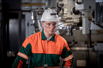Industry engineer wearing safety uniform control operating lathe grinding machine working in...