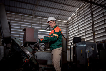 Fototapeta na wymiar Industry engineer wearing safety uniform control operating lathe grinding machine working in industry factory is metal manufacture industry concept.