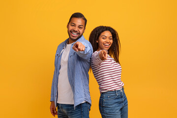 Positive Young Black Man And Woman Pointing With Fingers At Camera