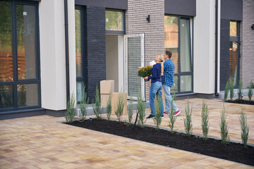 Fototapeta premium Back view photo of man and woman going towards house
