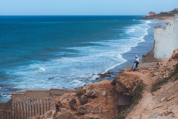 A man sitting watching the Atlantic Ocean in the coast of Tangier in Morocco