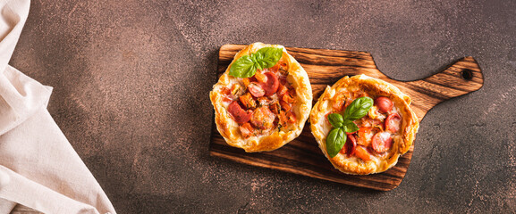 Chicago pizza pot pie with tomatoes, cheese and sausage on a wooden board top view web banner