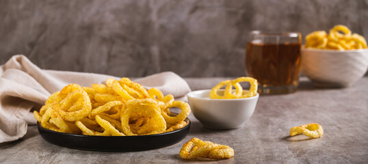 Fried crunchy onion rings, sauce and beer in a glass on the table web banner