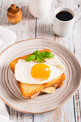 French croque madame hot breakfast sandwich on a plate on the table vertical view