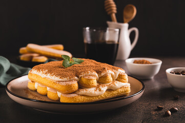 Tiramisu classic dessert with cookies, mascarpone and coffee on a plate on the table