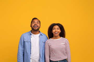 Portrait Of Amazed Young Black Couple Looking Up With Opened Mouth