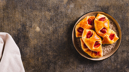 Pepperoni buns with cheese and sausage on a plate on the table top view web banner - obrazy, fototapety, plakaty
