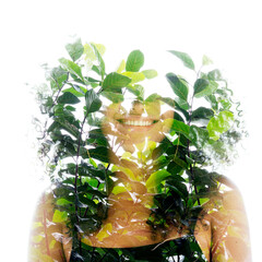 A double exposure portrait of a smiling woman merged with green leaves - 739351508