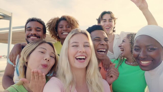 Happy blonde woman taking selfie with multi-ethnic friends outdoors