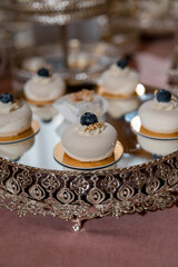 wedding mousse cakes on a candy bar on a gold stand