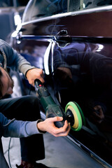 close-up of the hands of a car mechanic at a service station doing the final polishing to shine