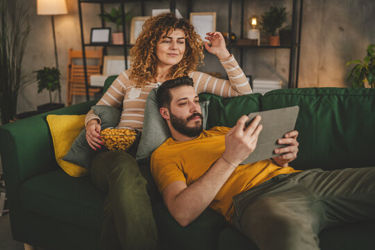 Couple caucasian man and woman at home on sofa bed watch movie